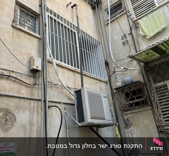מסגרת מתכת סביב חלון גדול בבניין ישן